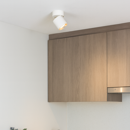 Modern kitchen with wooden cabinets, black faucet, and light-colored countertops.