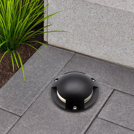 Black garden light fixture on a stone patio with grass