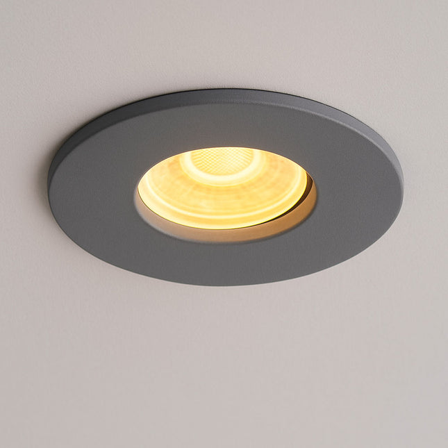 Round recessed ceiling light with gold interior on a gray background