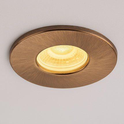 Round gold ceiling light fixture on a gray background